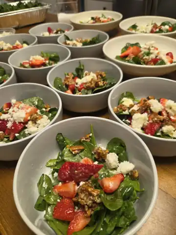 Spinach and strawberry salads with candied pecans and goat cheese for a wellness retreat