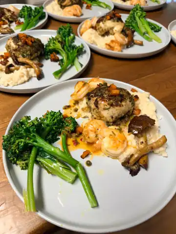Herb crusted chicken and shrimp over risotto with broccolini, plated by Chef Zak